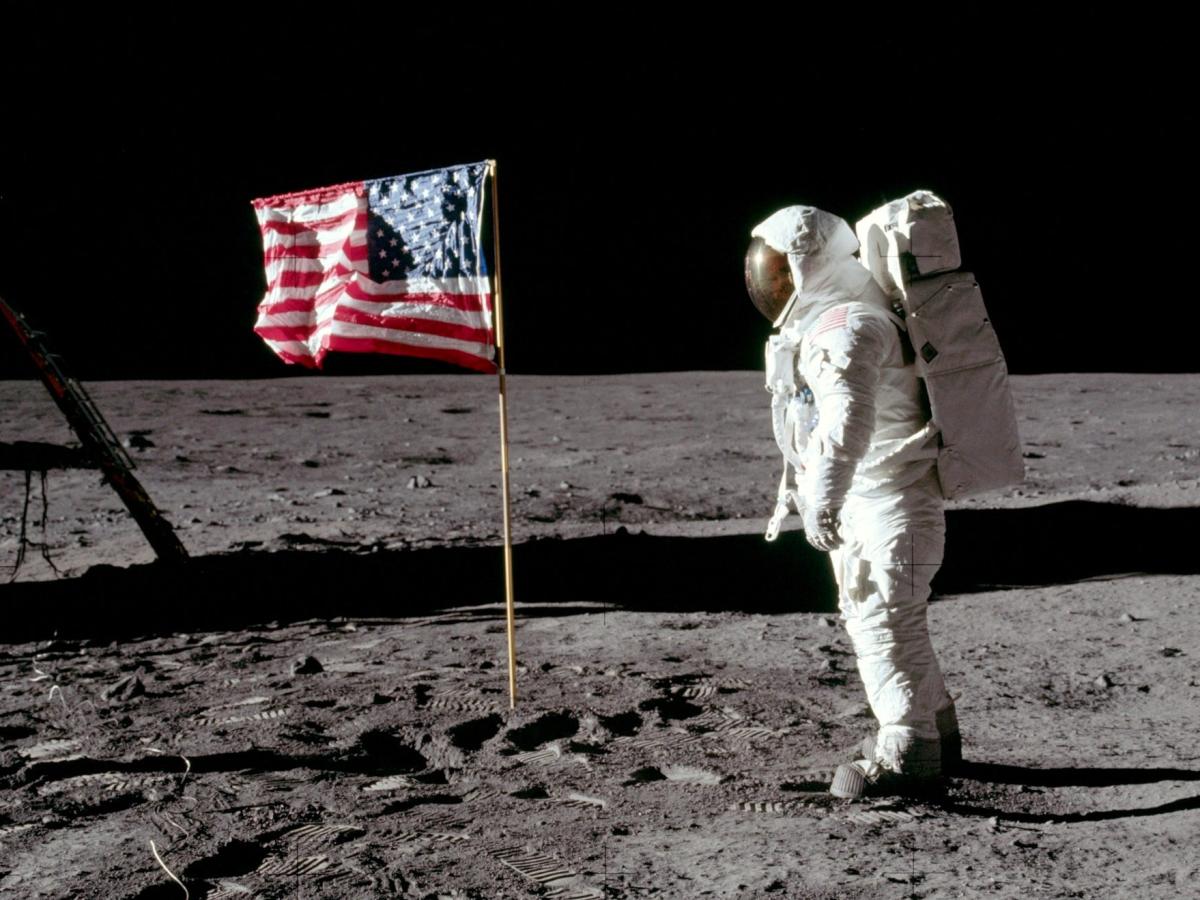 Neil Armstrong on the moon with the American flag.